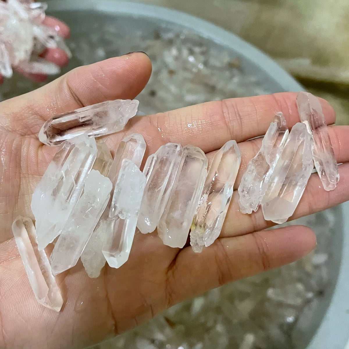 Puñado de puntas de cuarzo transparente natural en bruto